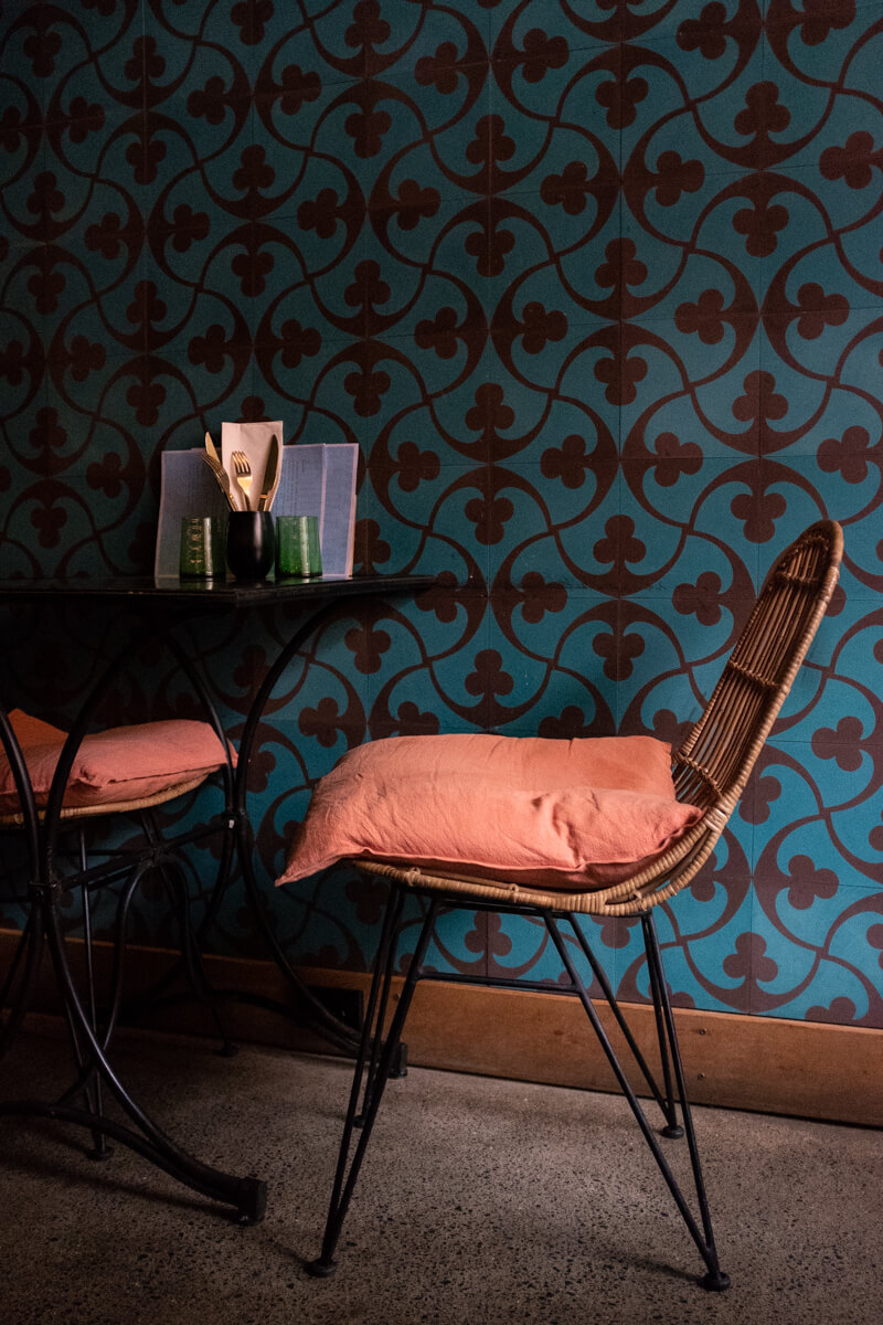 The cane seating and turquoise wallpaper. Photo: Alex Blackwood